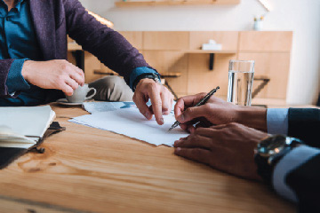 Person signing a paper